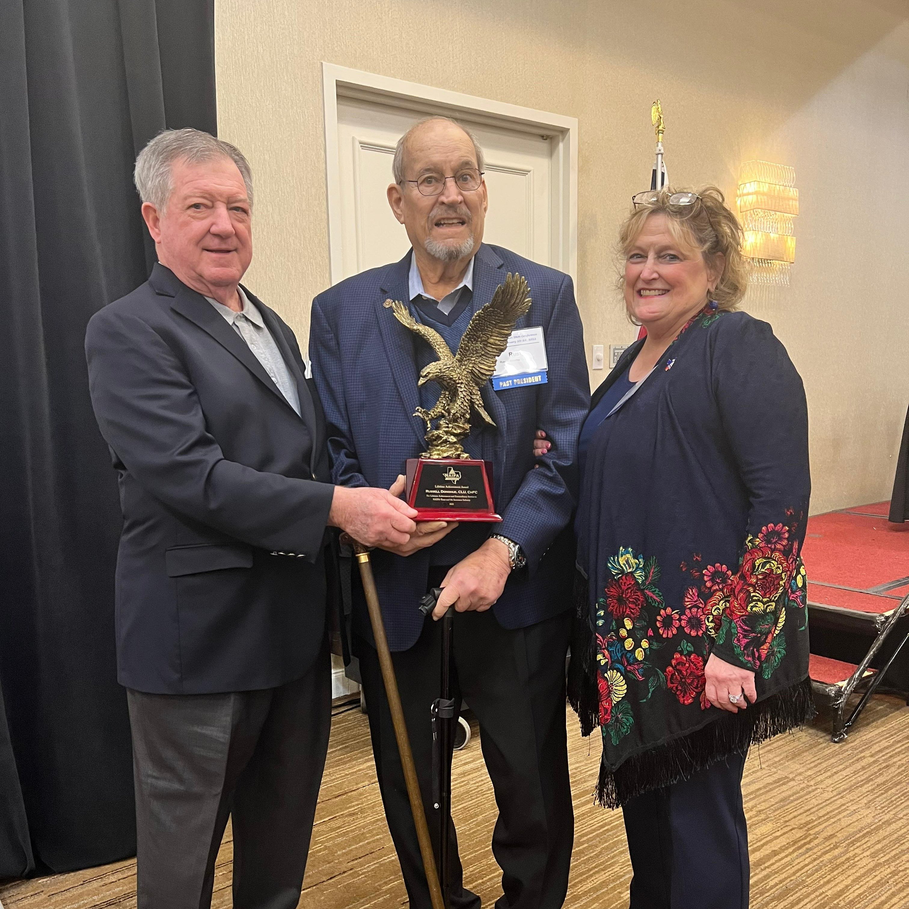 John Ruckel presents Rusty Donohue (accompanied by Hollie Gandy-Donohue) with the Lifetime Achievement Award